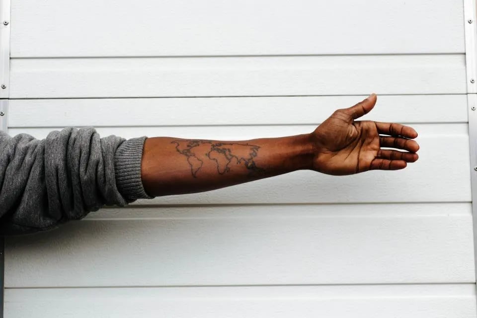 Fine line world map on an outstretched forearm